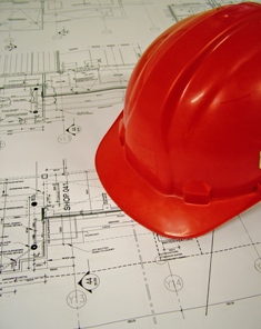 This photo of a hard hat resting on construction blueprints was taken by South African photographer "Lotus Head".